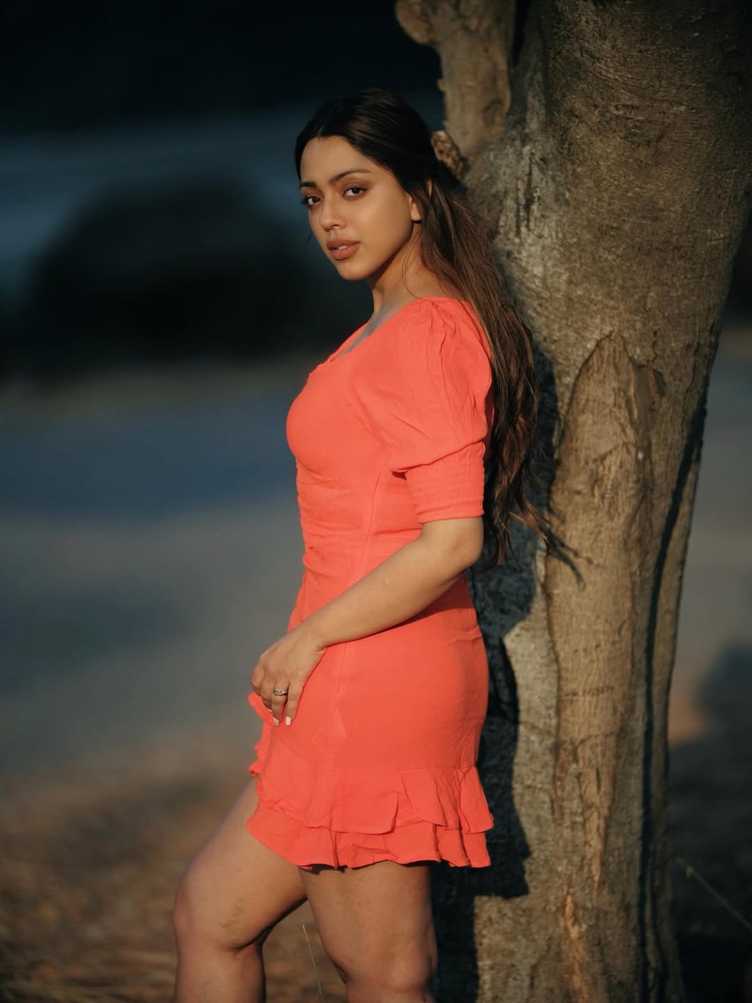 Deviyani Sharma in vibrant coral sunset dress