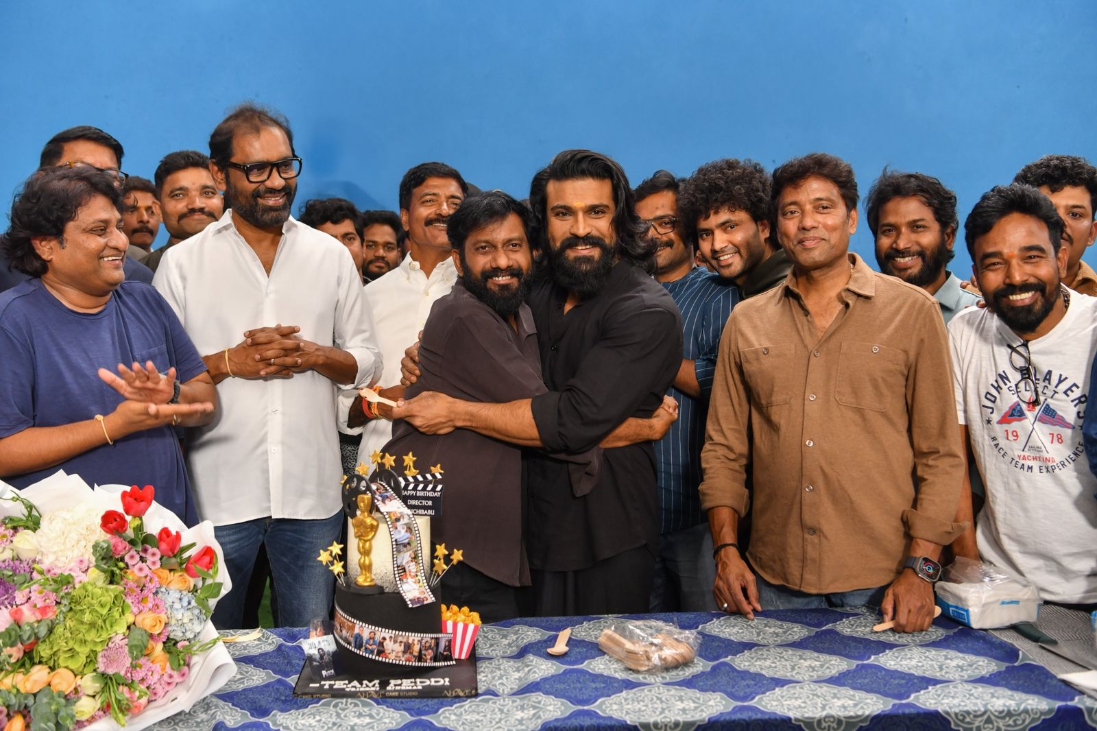 Buchi Babu and Ram Charan smiling at celebration