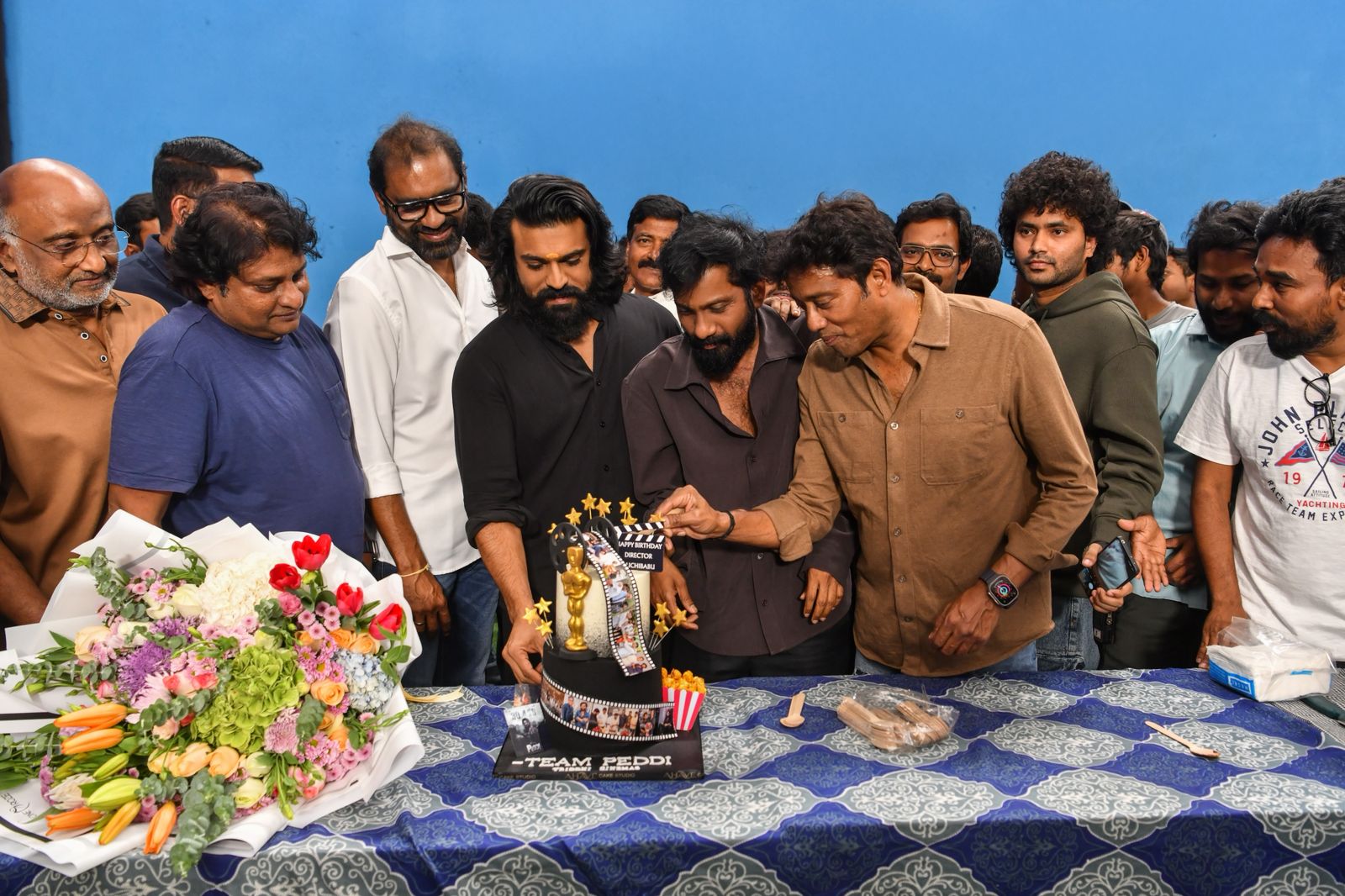 Buchi Babu cutting birthday cake with Ram Charan