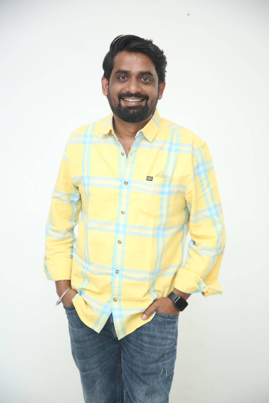 Gopi Atchara wearing yellow plaid shirt smiling