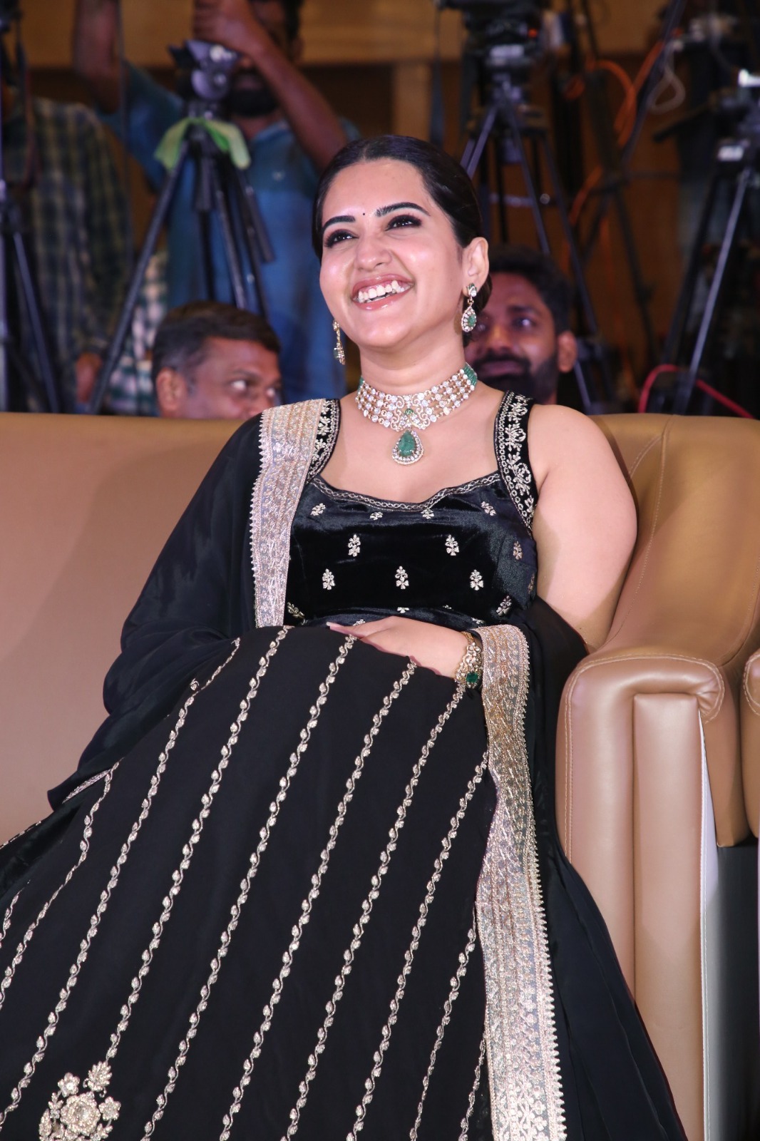 Sravanthi laughing while seated at event