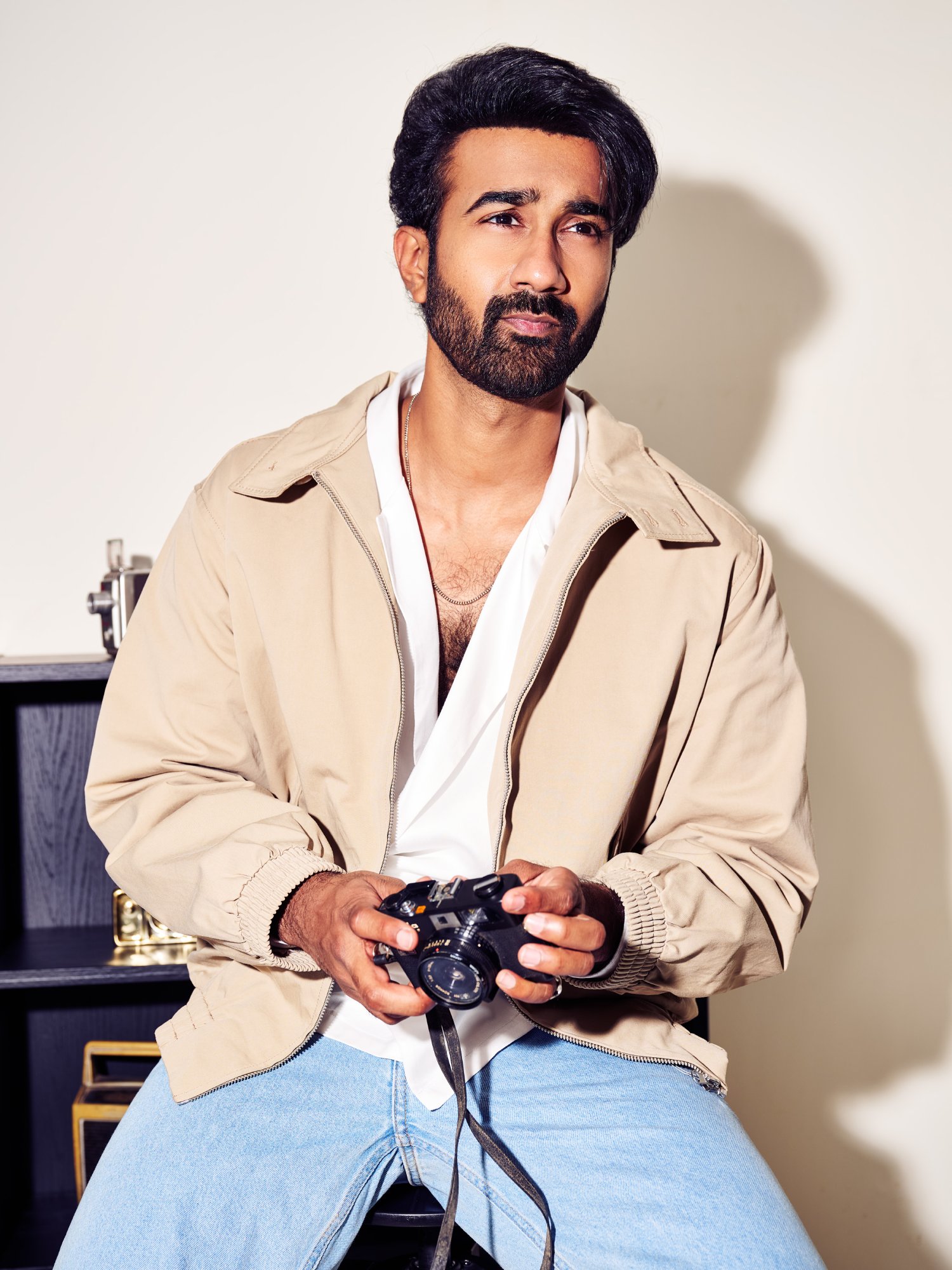 Santosh Sobhan posing stylishly holding a camera