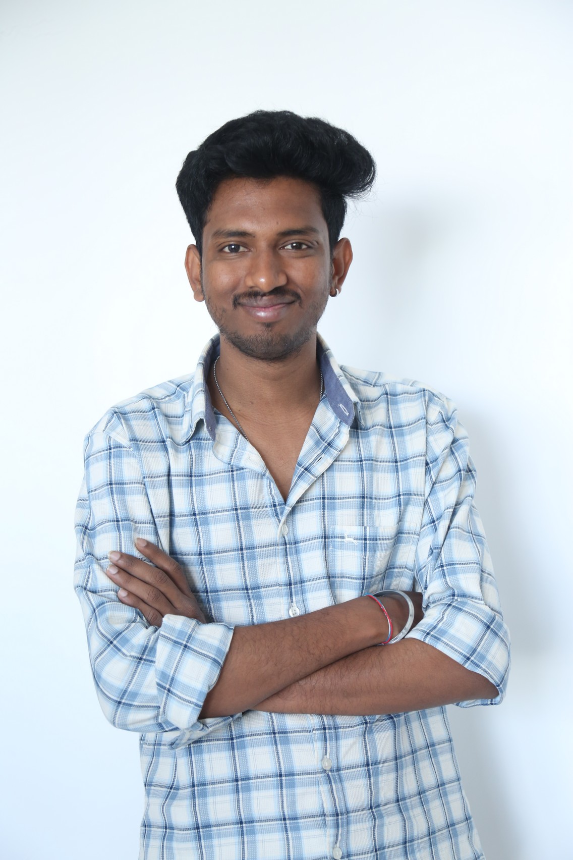 Vinay Ratnam confident grin in checkered shirt