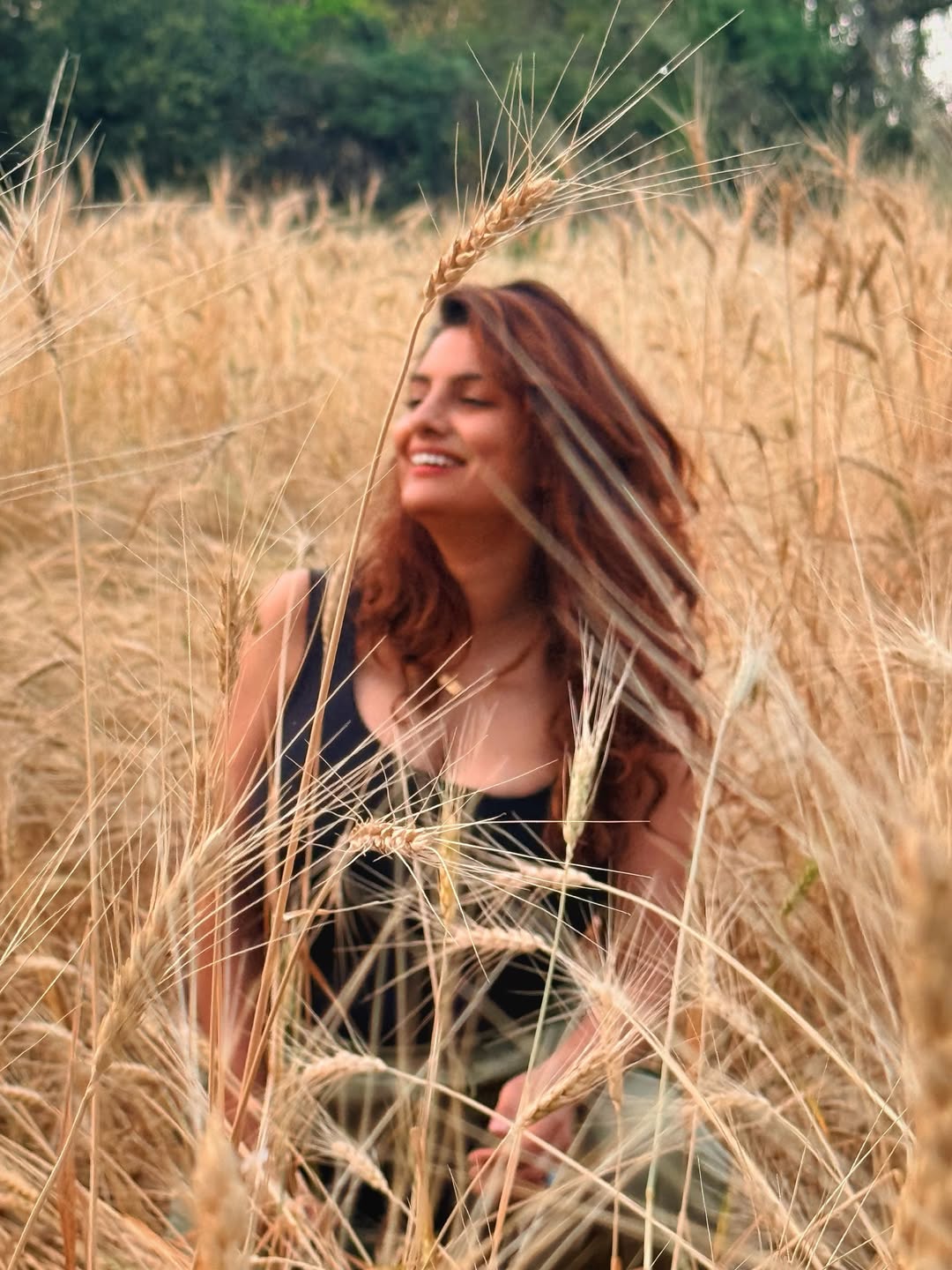 Anveshi Jain posing stylishly in scenic wheat fields