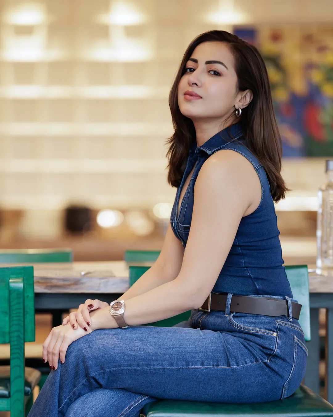 Catherine Tresa posing in sleeveless top and fitted jeans