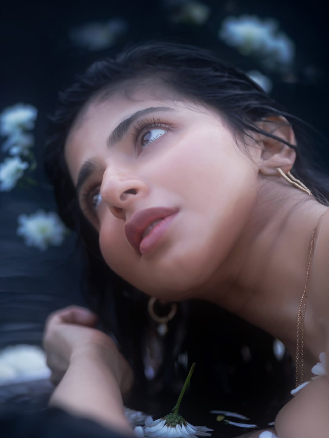 Iswarya Menon chic water pose with floating flowers