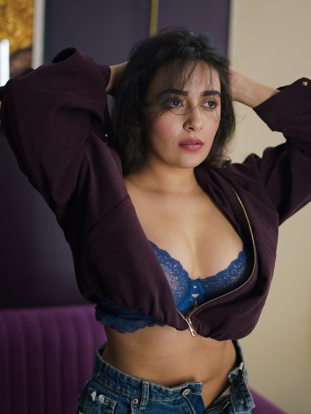 Jinal Joshi posing confidently in stylish lace bralette and denim shorts with maroon jacket