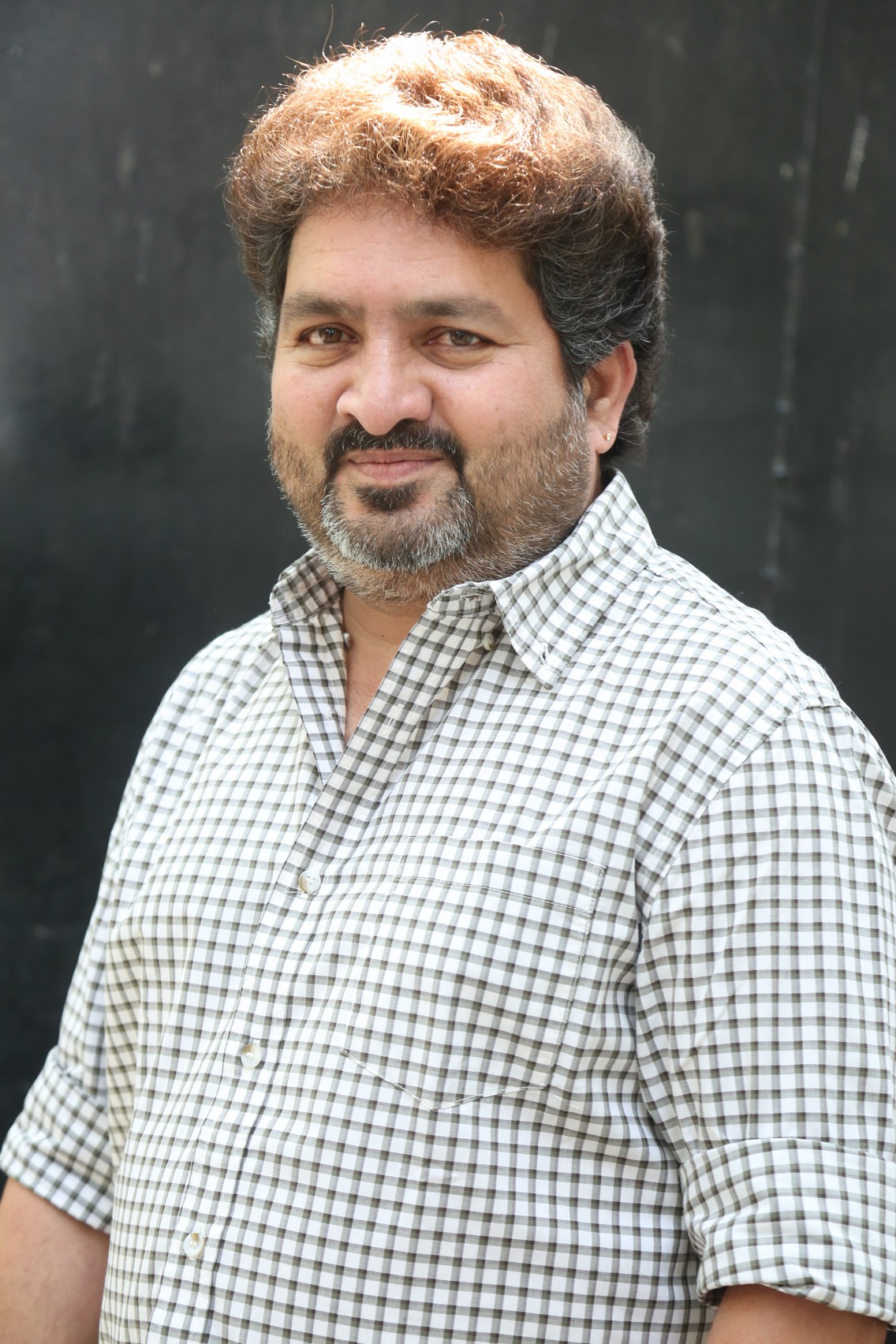 Kasarla Shyam confident pose in checkered shirt