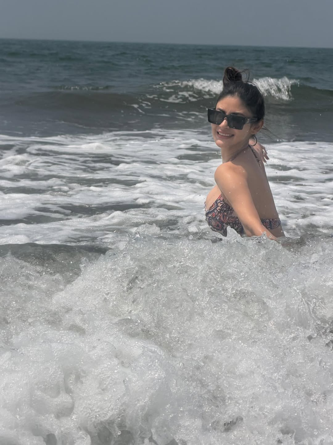 Mouni Roy posing by ocean in chic outfit