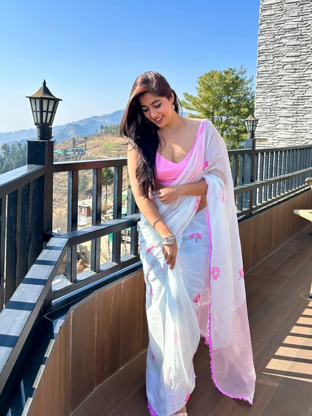 Nikita Sharma graceful white saree pose with mountain view