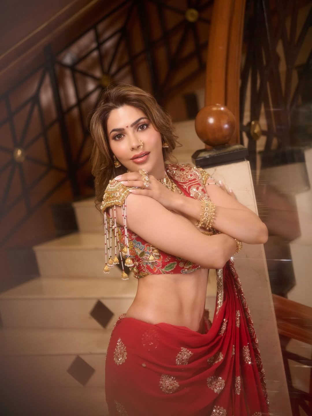 Nikki Tamboli red ensemble elegant glamorous confident pose