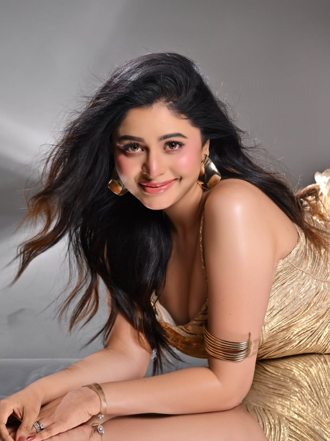 Ritabhari Chakraborty glowing in gold dress with radiant smile