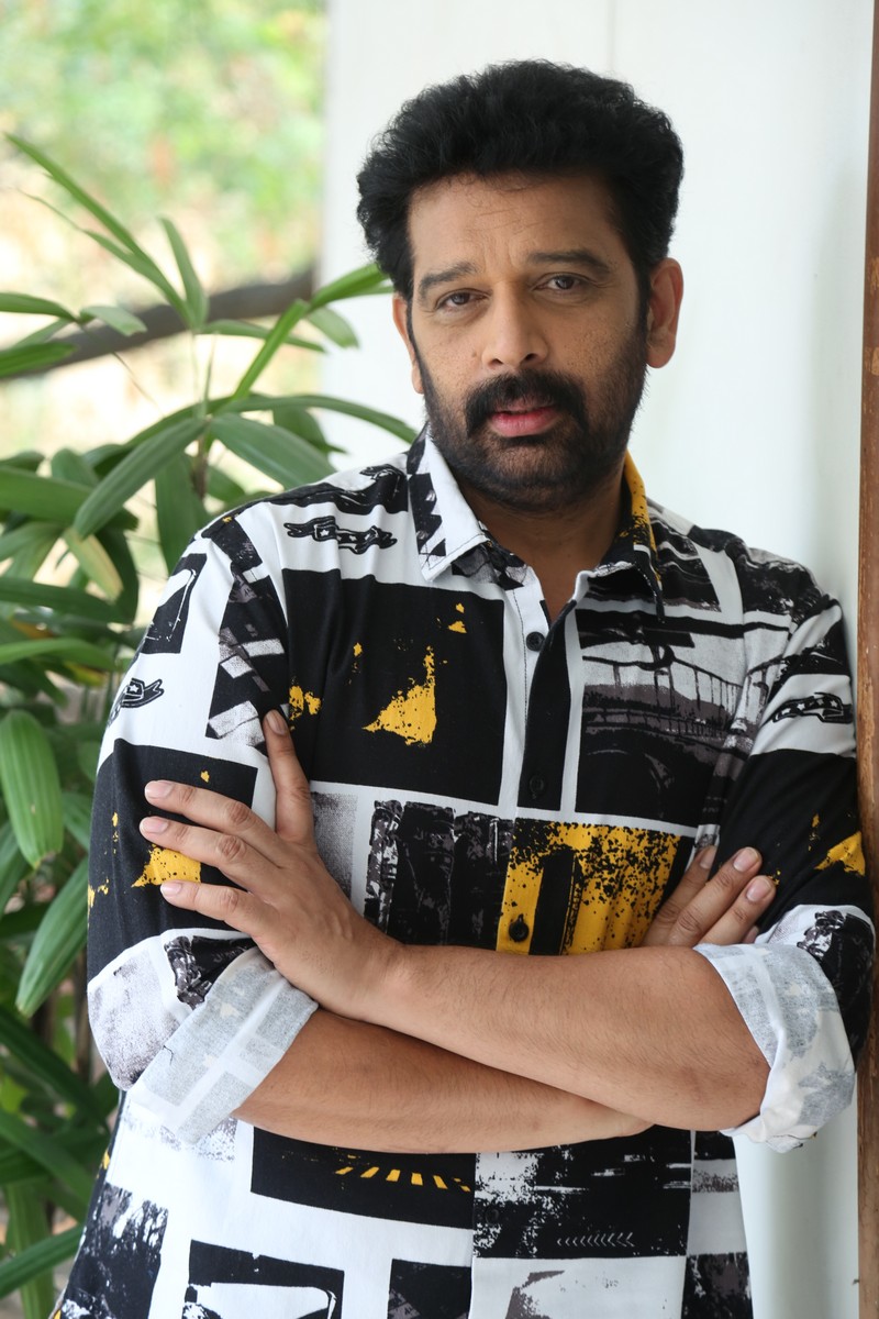 J D Chakravarthy sharp dress confident stance arms crossed pose