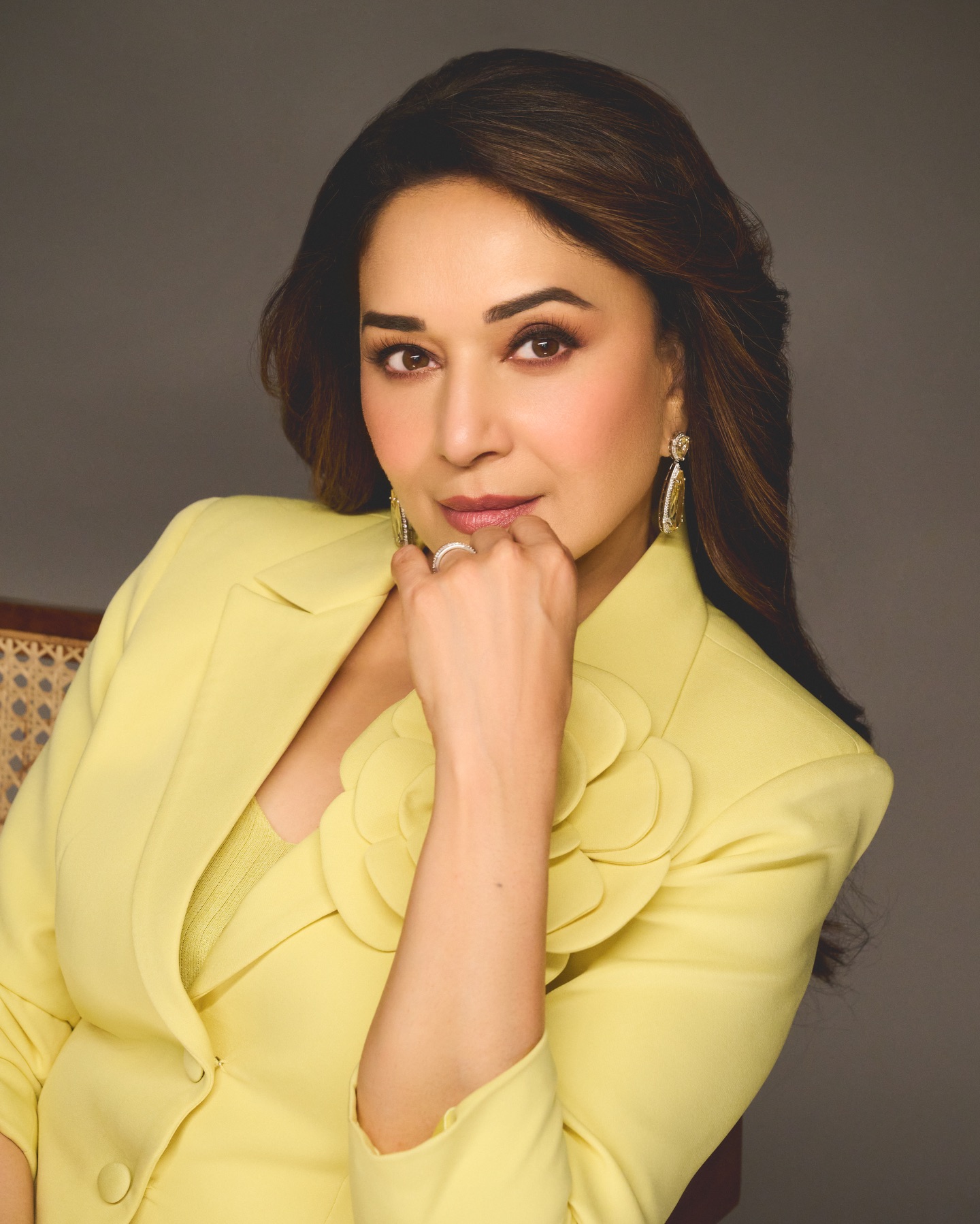 Madhuri Dixit standing elegantly in statement yellow outfit with minimal accessories