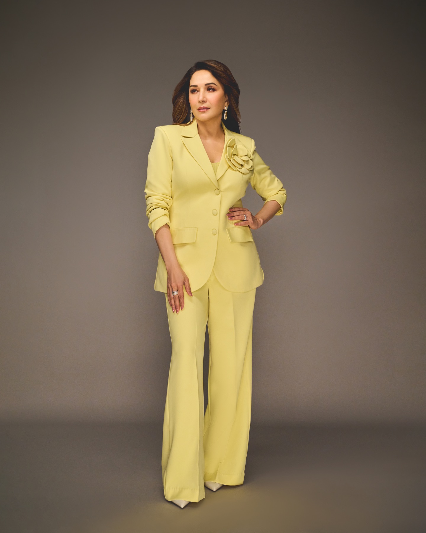 Madhuri Dixit confidently posing in modern yellow co-ord suit with sleek styling