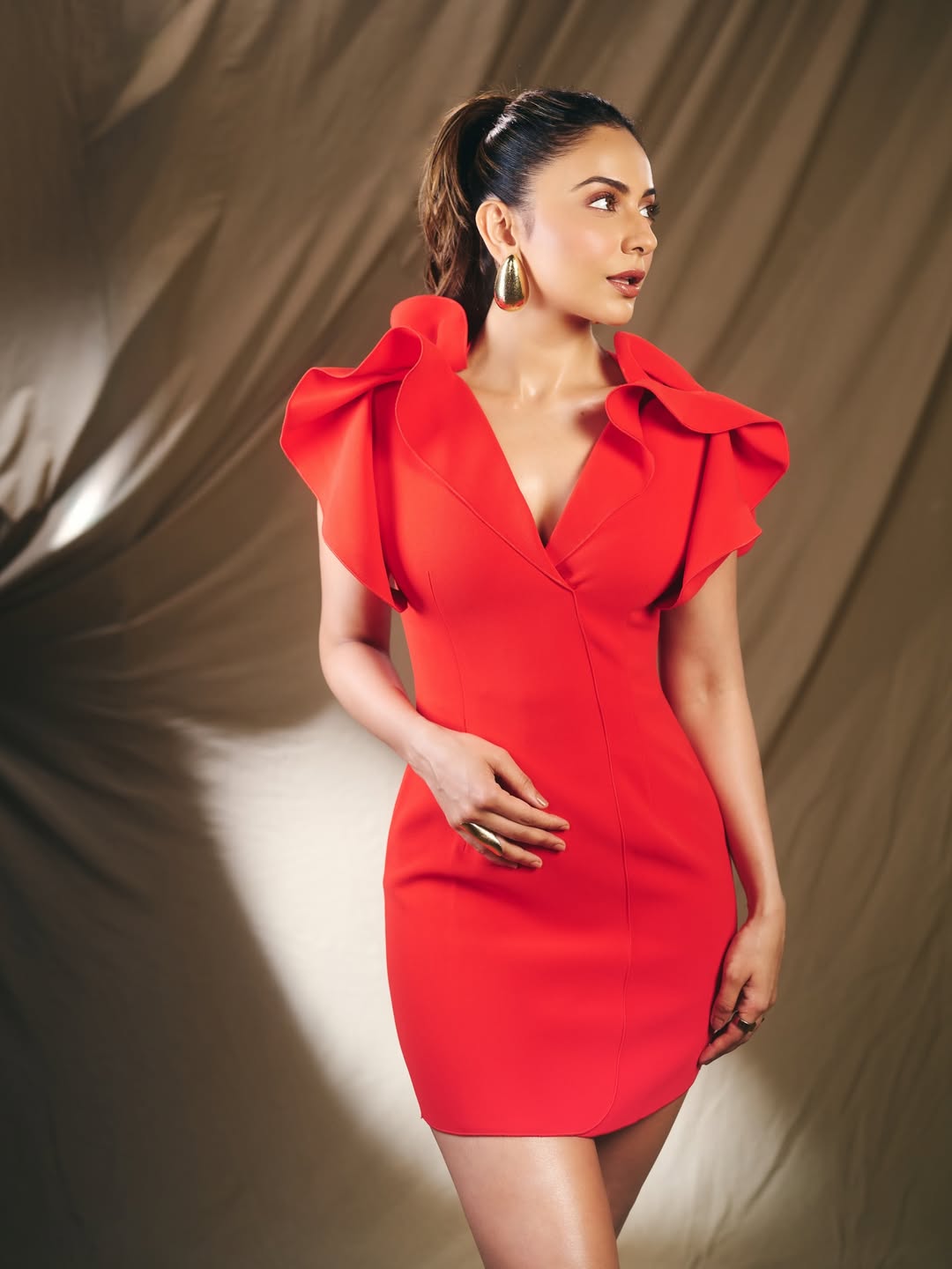 Rakul Preet Singh posing in fitted red dress