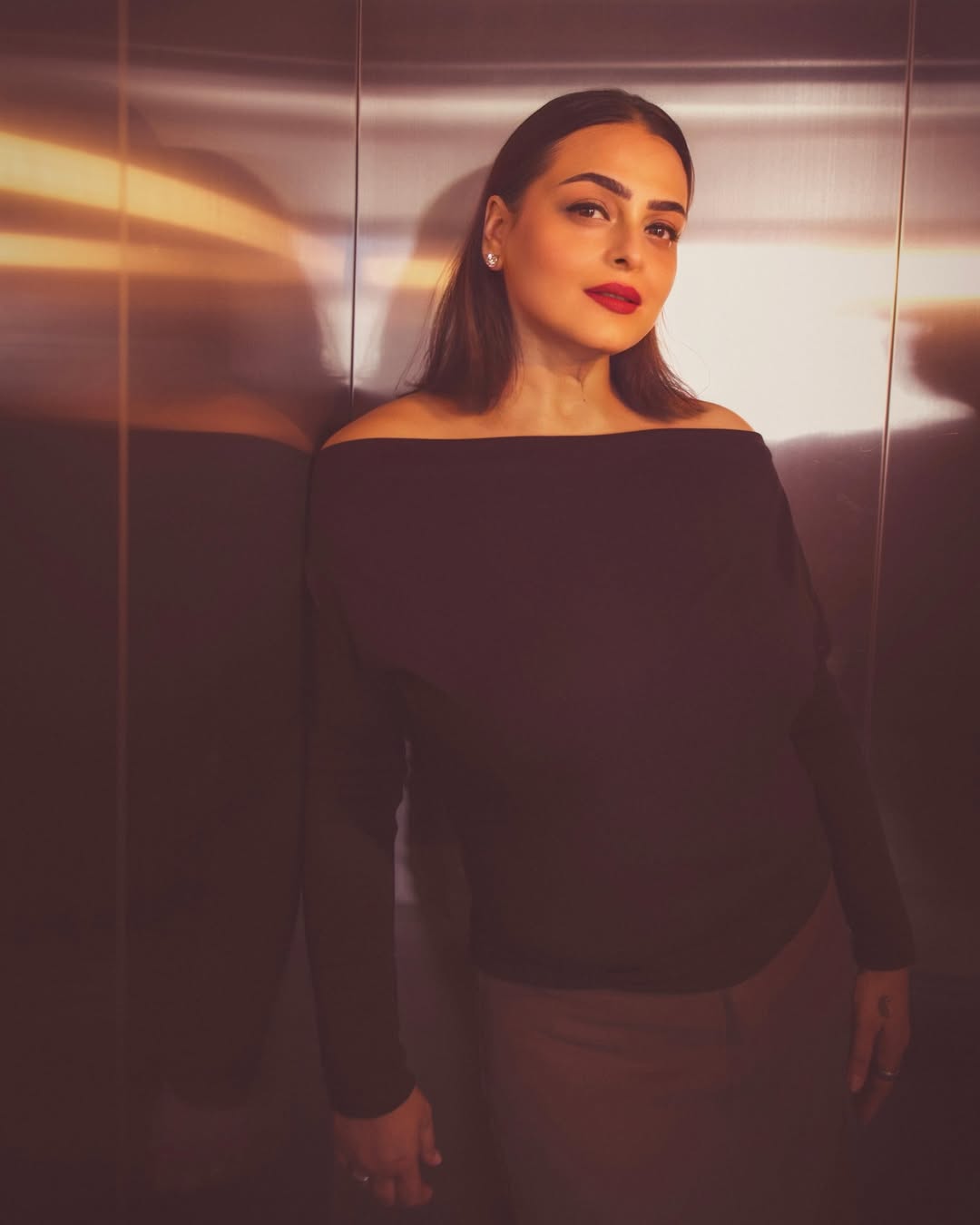 Shilpa Shirodkar in an off-shoulder black dress posing confidently with graceful posture