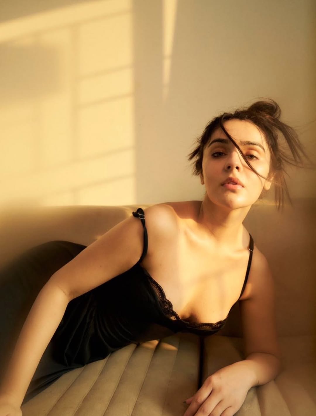 Sidhika Sharma posing in a black outfit with soft sunlight enhancing her elegant look