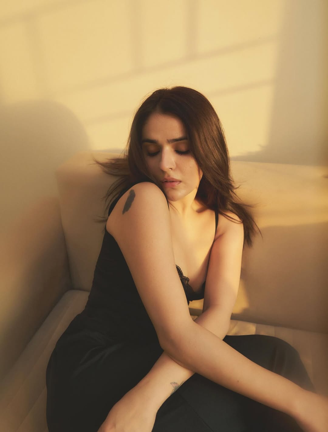 Sidhika Sharma posing in a little black dress with minimal styling and spotlight effect