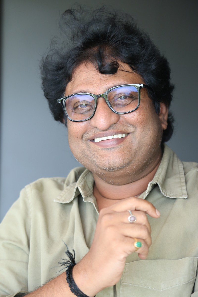 Avinash Kolla smiling in glasses with classy outfit
