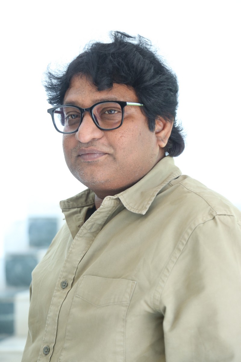 Avinash Kolla wearing a stylish khaki shirt and glasses