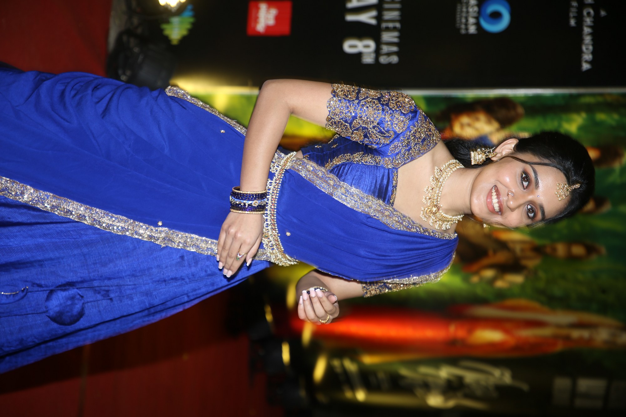 Nidhi Pradeep in a royal blue and gold embellished saree during a glamorous appearance.