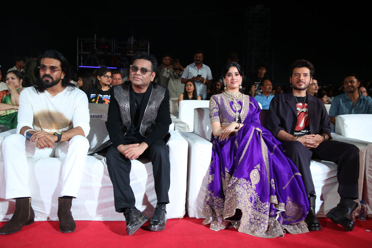 Ram Charan, A.R. Rahman, Janhvi Kapoor, and Divyendu Sharma seated during a film promotional event.