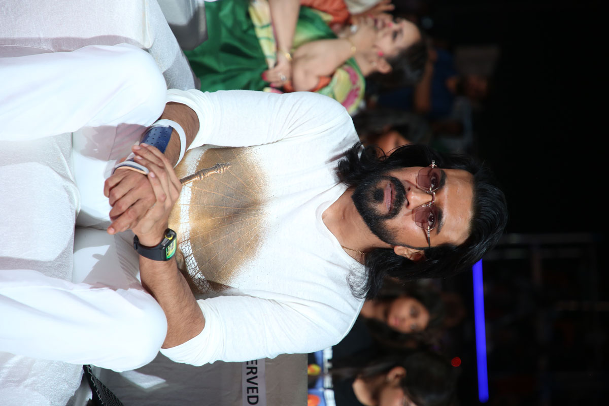 Ram Charan seated during a grand promotional gathering for the upcoming film.