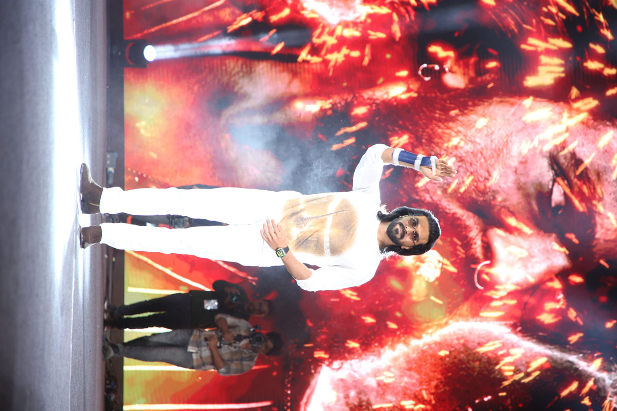 Ram Charan greeting the audience during a grand film event.
