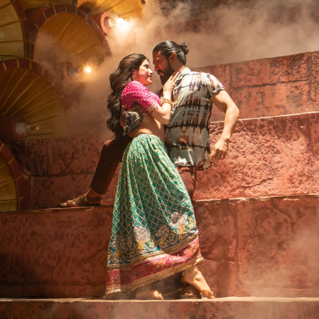 Ram Charan dancing with Janhvi Kapoor in colorful Peddi song sequence.