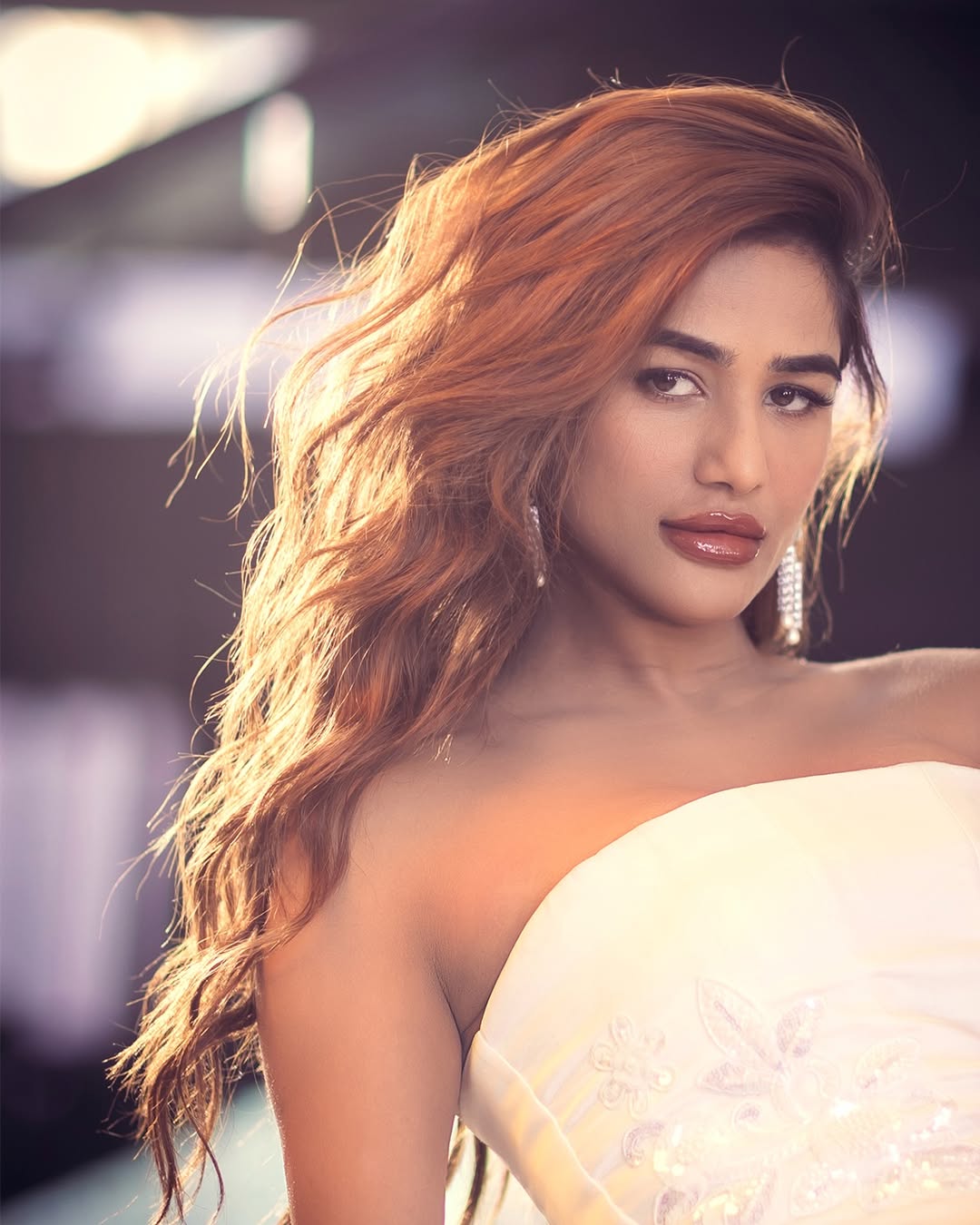Poonam Pandey posing elegantly in shimmering white couture