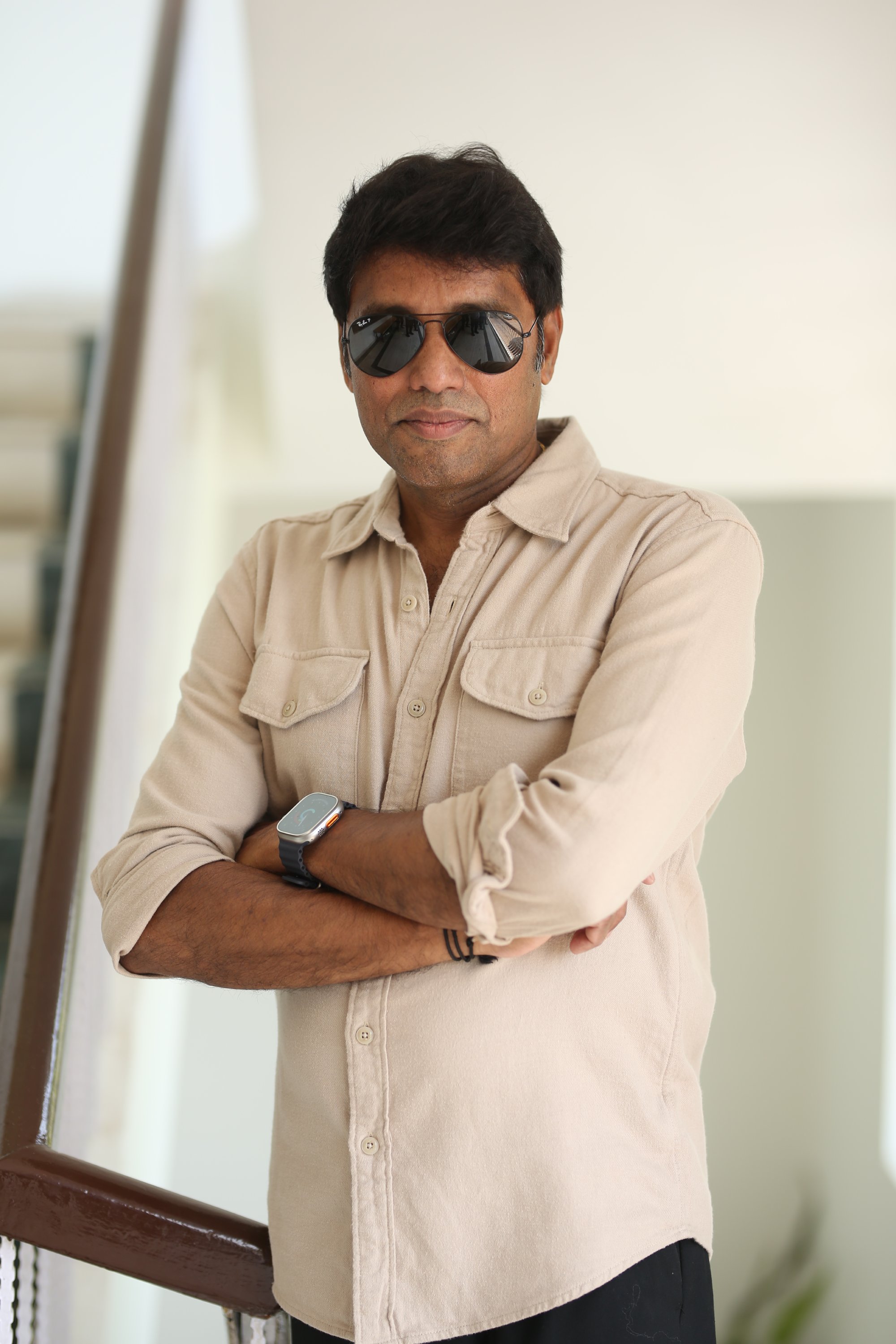 Rathnavelu wearing beige casual outfit with stylish accessories.
