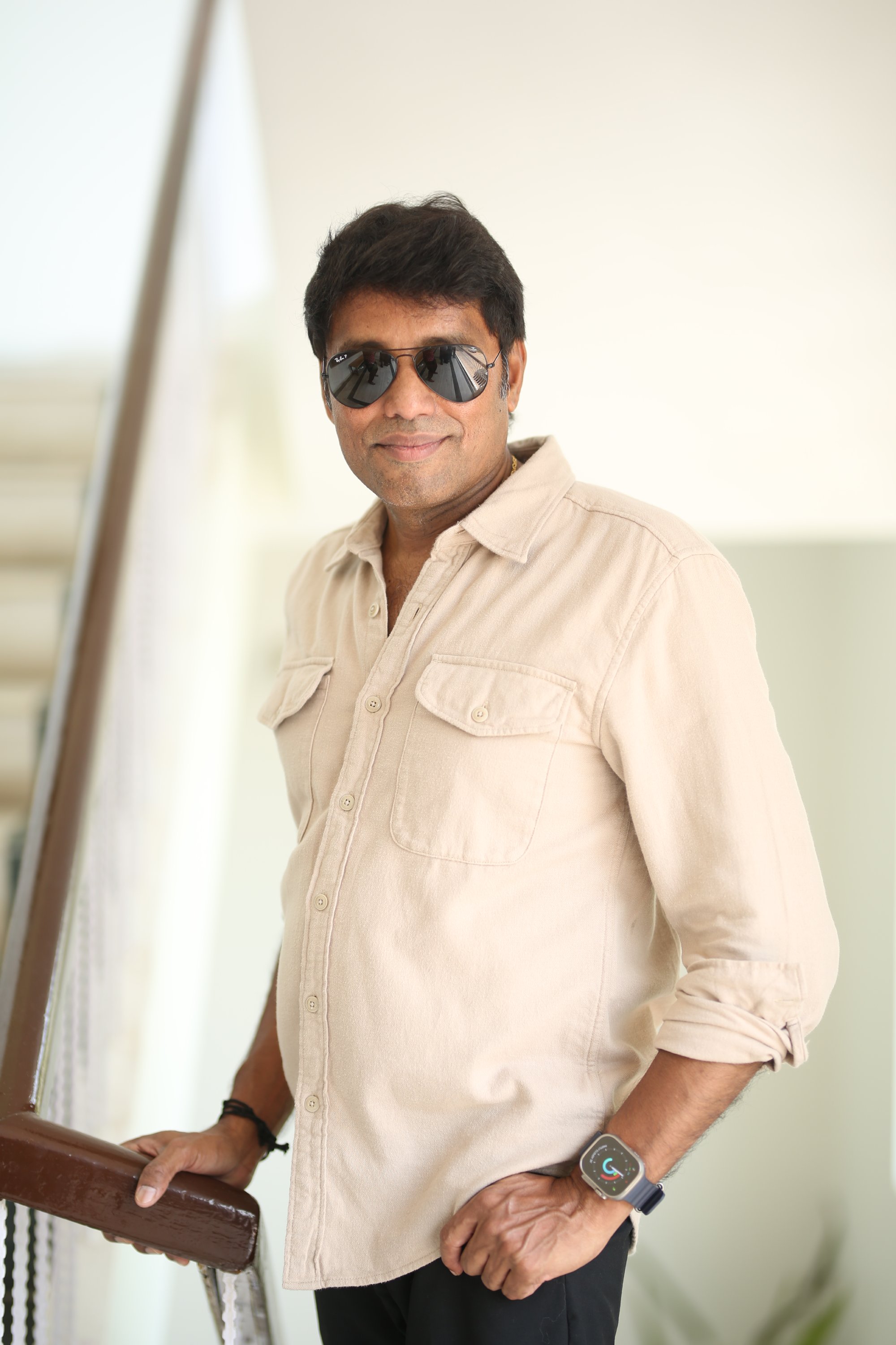 Cinematographer Rathnavelu in relaxed stylish photoshoot pose.