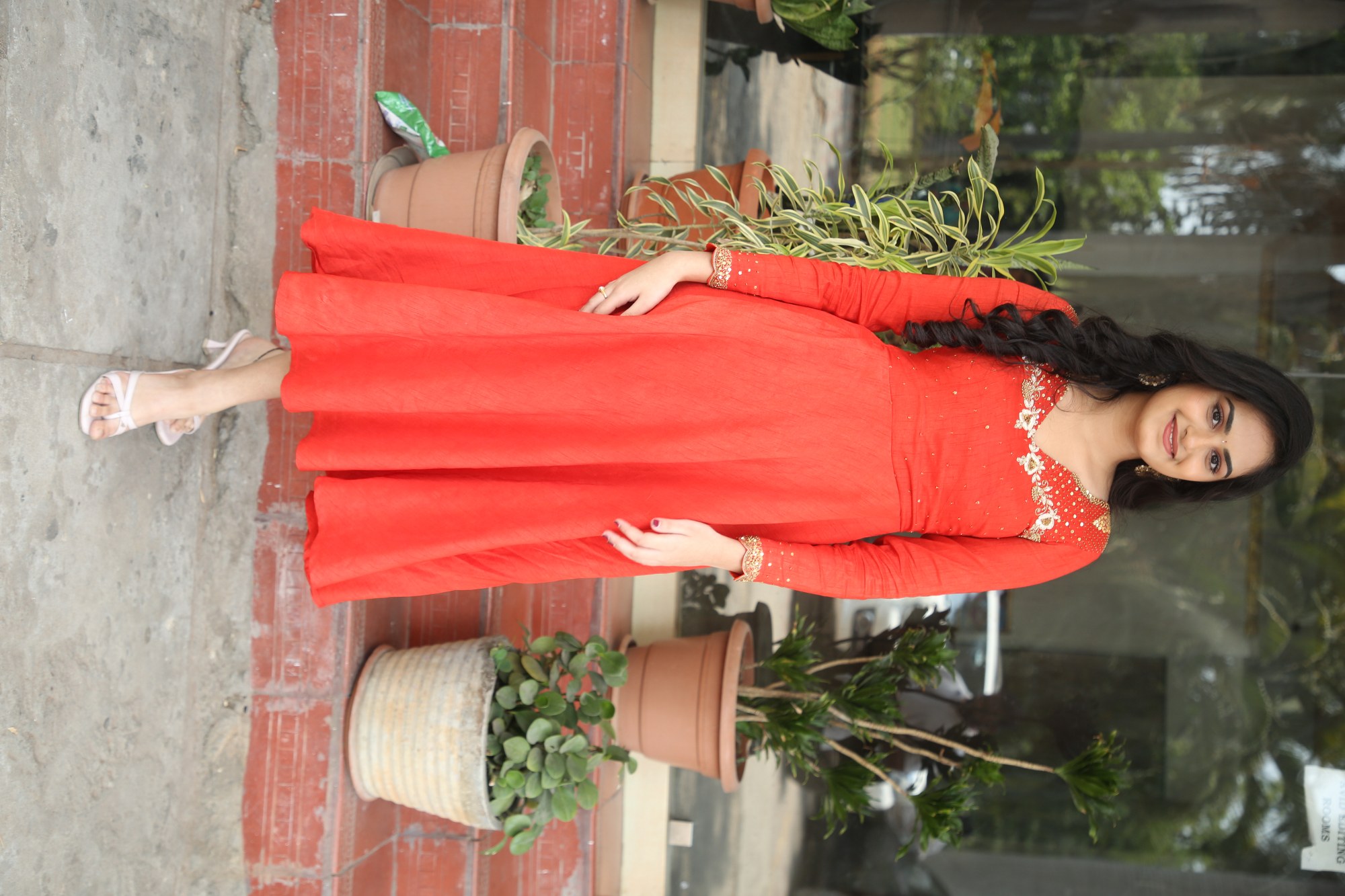 Rayancha Kokkura posing stylishly in glamorous red attire