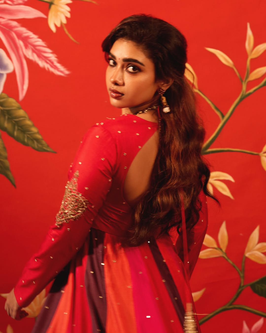 Dushara Vijayan posing in a colorful striped outfit with confidence.