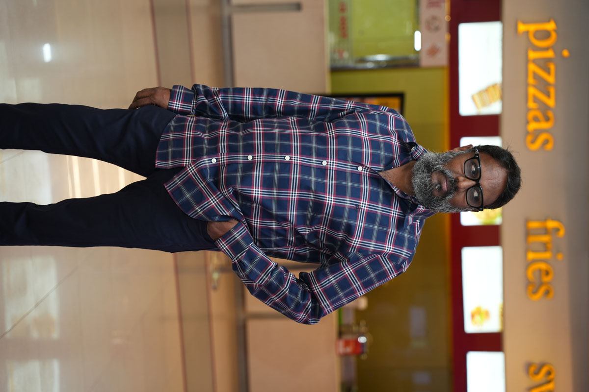 Gunasekhar wearing plaid shirt with confident pose
