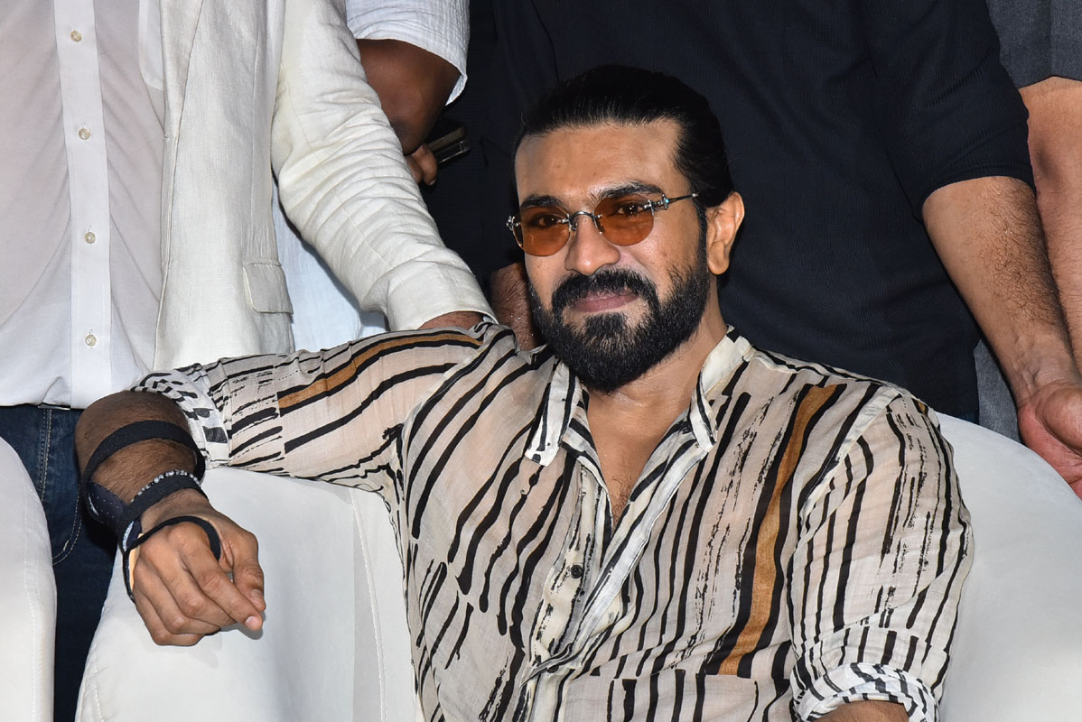 Ram Charan seated during Peddi promotional event in Vijayawada.