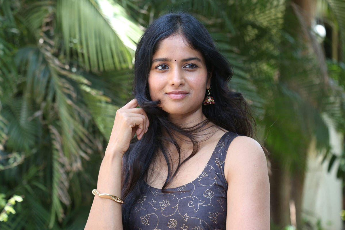 Shalini Kondepudi posing elegantly outdoors in a stylish outfit surrounded by greenery.