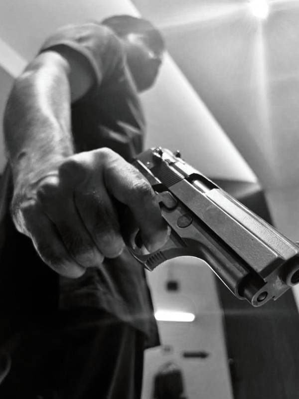 கையில் துப்பாக்கியுடன்